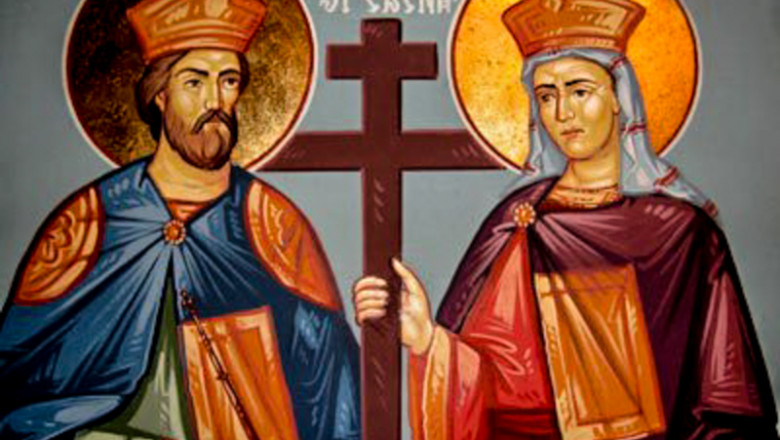 Icon depicting two haloed figures in traditional Eastern Orthodox vestments, one holding a cross, with stylized gold and red backgrounds.